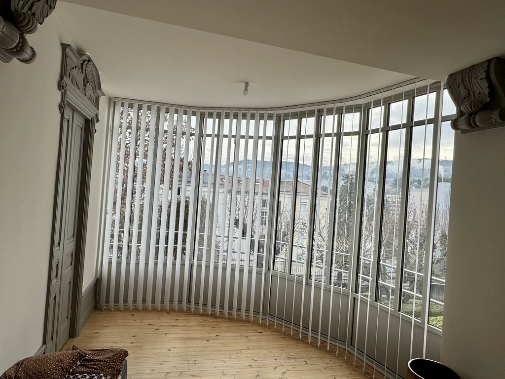 Stores à bandes verticales sur une véranda en arrondi
