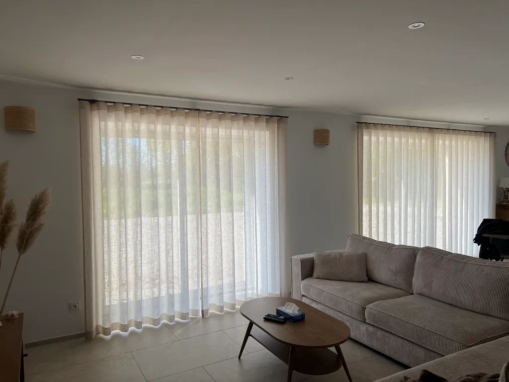 Voilages tamisants en lin sur double baie d'un séjour contemporain